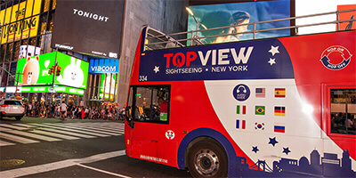 a TopView Double Decker Bus in Time Square at Night